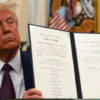 President Donald Trump displays a signed executive order on science and technology while seated in the Oval Office at the White House. Photo/ Courtesy.