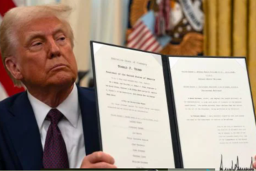 President Donald Trump displays a signed executive order on science and technology while seated in the Oval Office at the White House. Photo/ Courtesy.