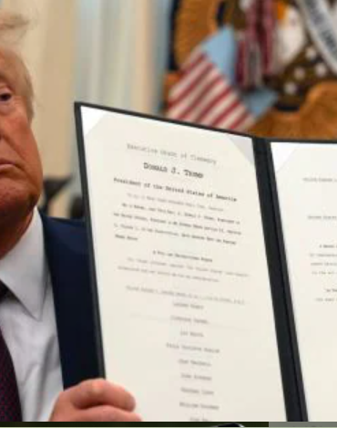 President Donald Trump displays a signed executive order on science and technology while seated in the Oval Office at the White House. Photo/ Courtesy.