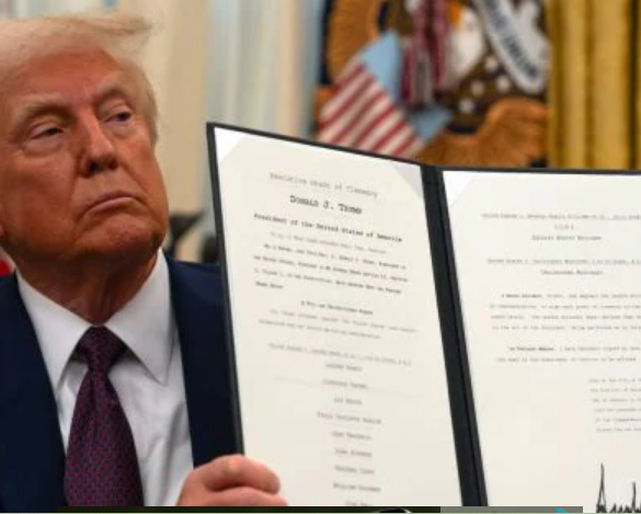 President Donald Trump displays a signed executive order on science and technology while seated in the Oval Office at the White House. Photo/ Courtesy.