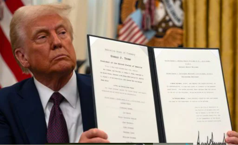 President Donald Trump displays a signed executive order on science and technology while seated in the Oval Office at the White House. Photo/ Courtesy.