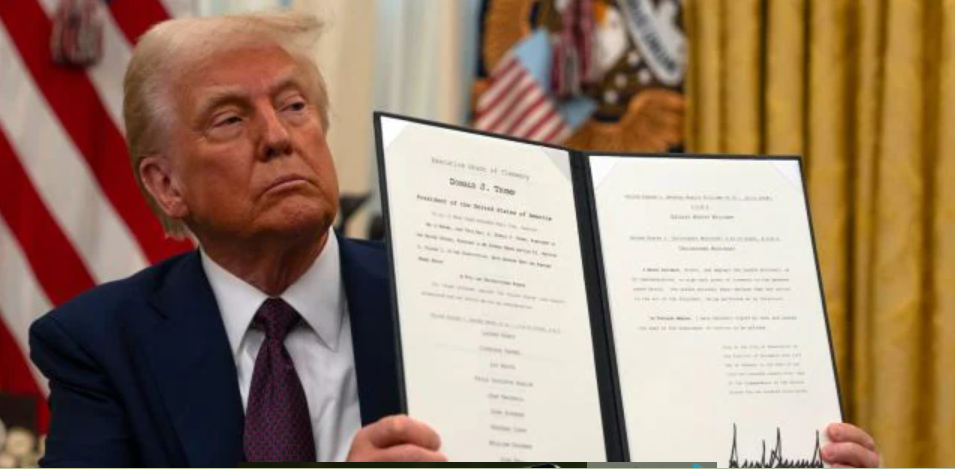 President Donald Trump displays a signed executive order on science and technology while seated in the Oval Office at the White House. Photo/ Courtesy.